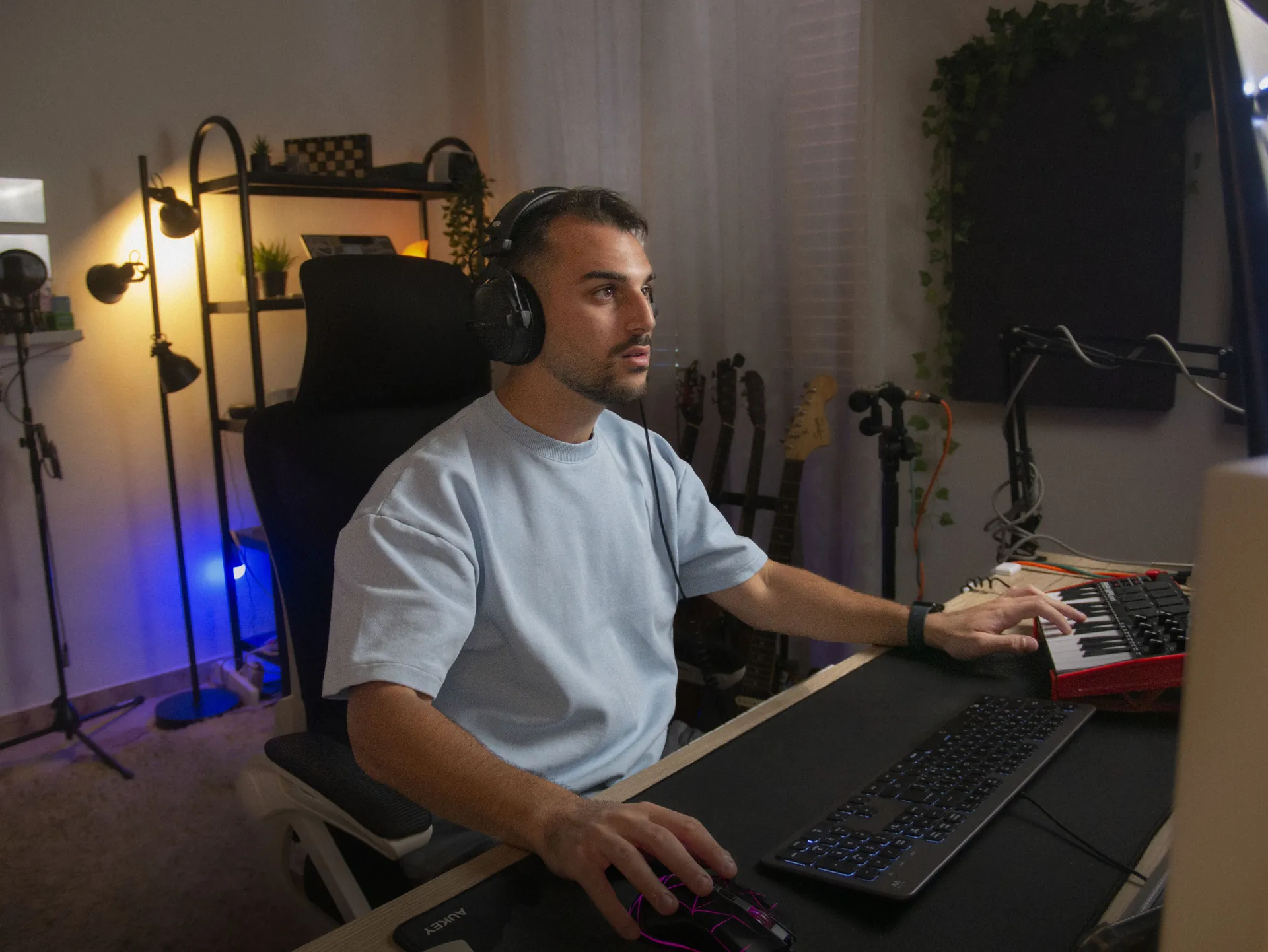 Daniele Mazzè al lavoro in studio, con le cuffie, davanti alla tastiera MIDI