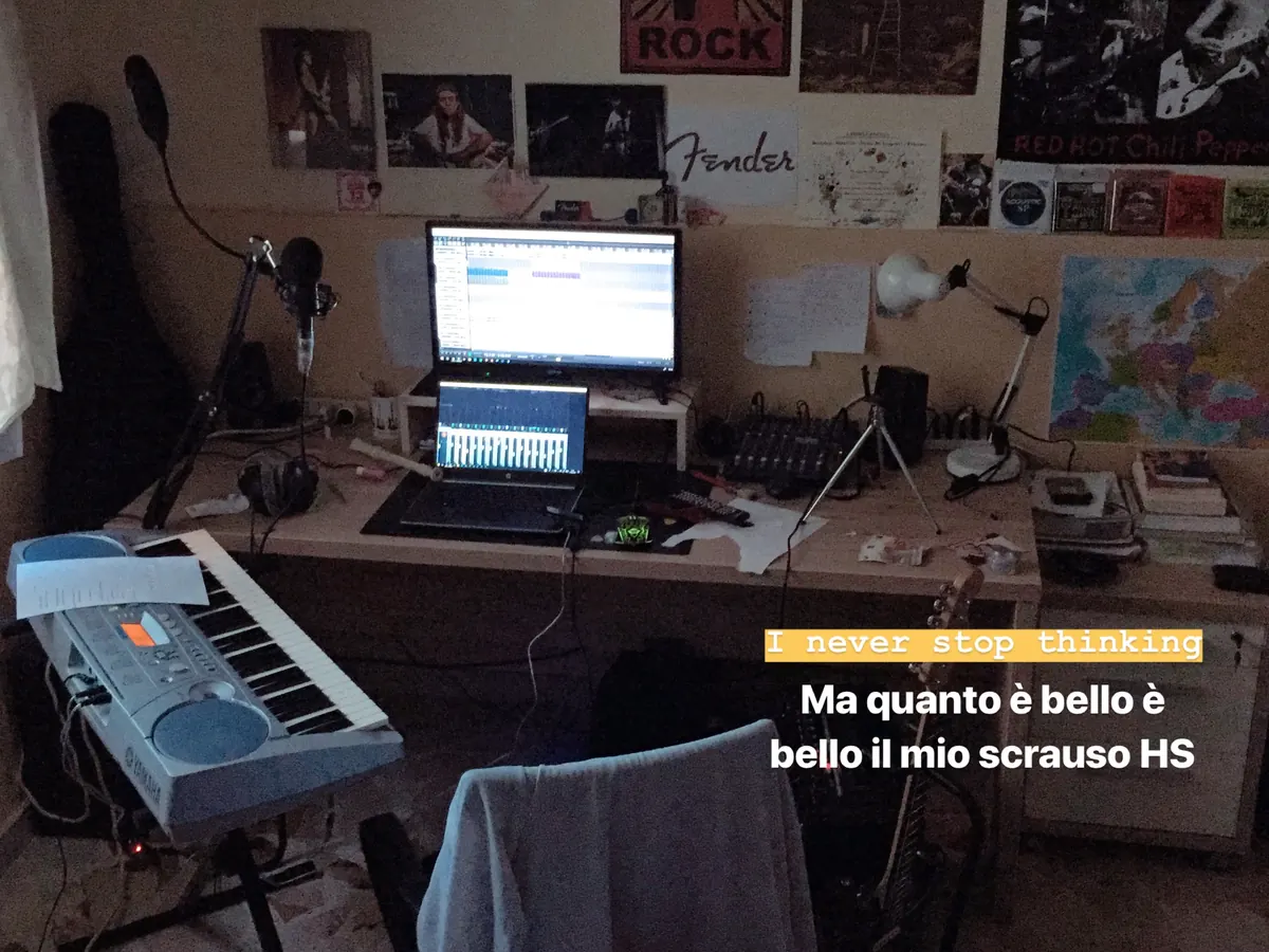 Postazione con tastiera, laptop e poster alle pareti